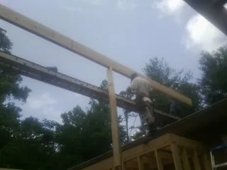 Carpenter setting a ridge beam over a new addition frame — Ice Dam Removal by Roofing Brothers in East Ryegate