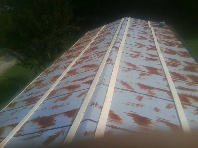 Rusted metal roof panels with new wood purlins before replacement — Storm Damage Roof Repair in East Ryegate by Roofing Brothers