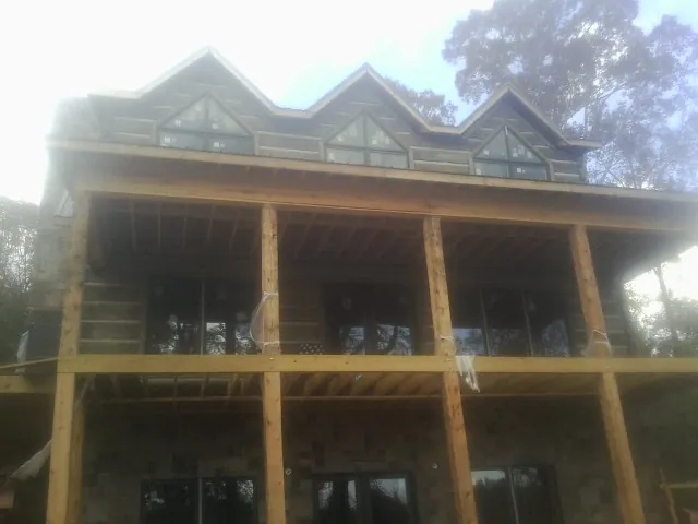 Dormers and porch framing on a large log home under construction — Roof Coating work by our crew in East Ryegate